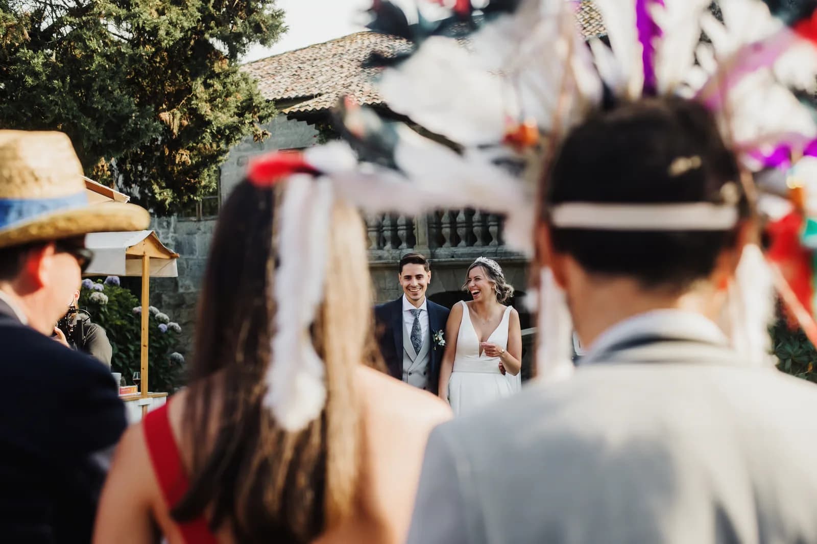 A newly married couple laughing as their guests look on